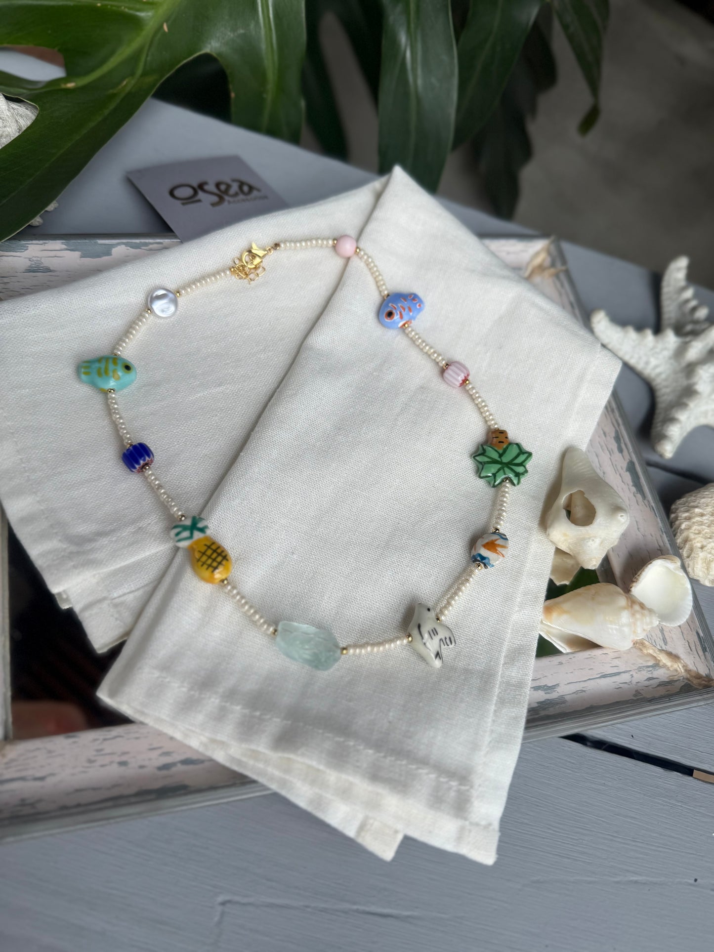 Collar corto en mostacilla con dijes en cerámica y murrina.