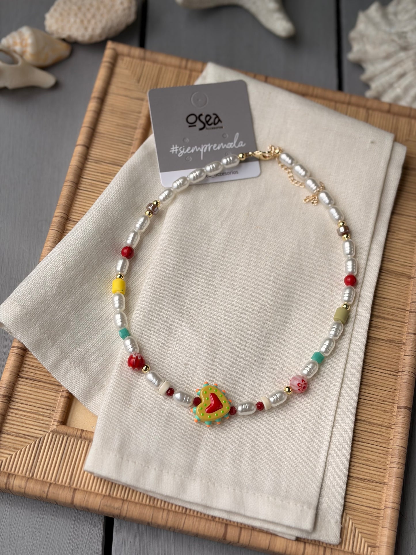 Collar corto con perlas plásticas y dijes variados