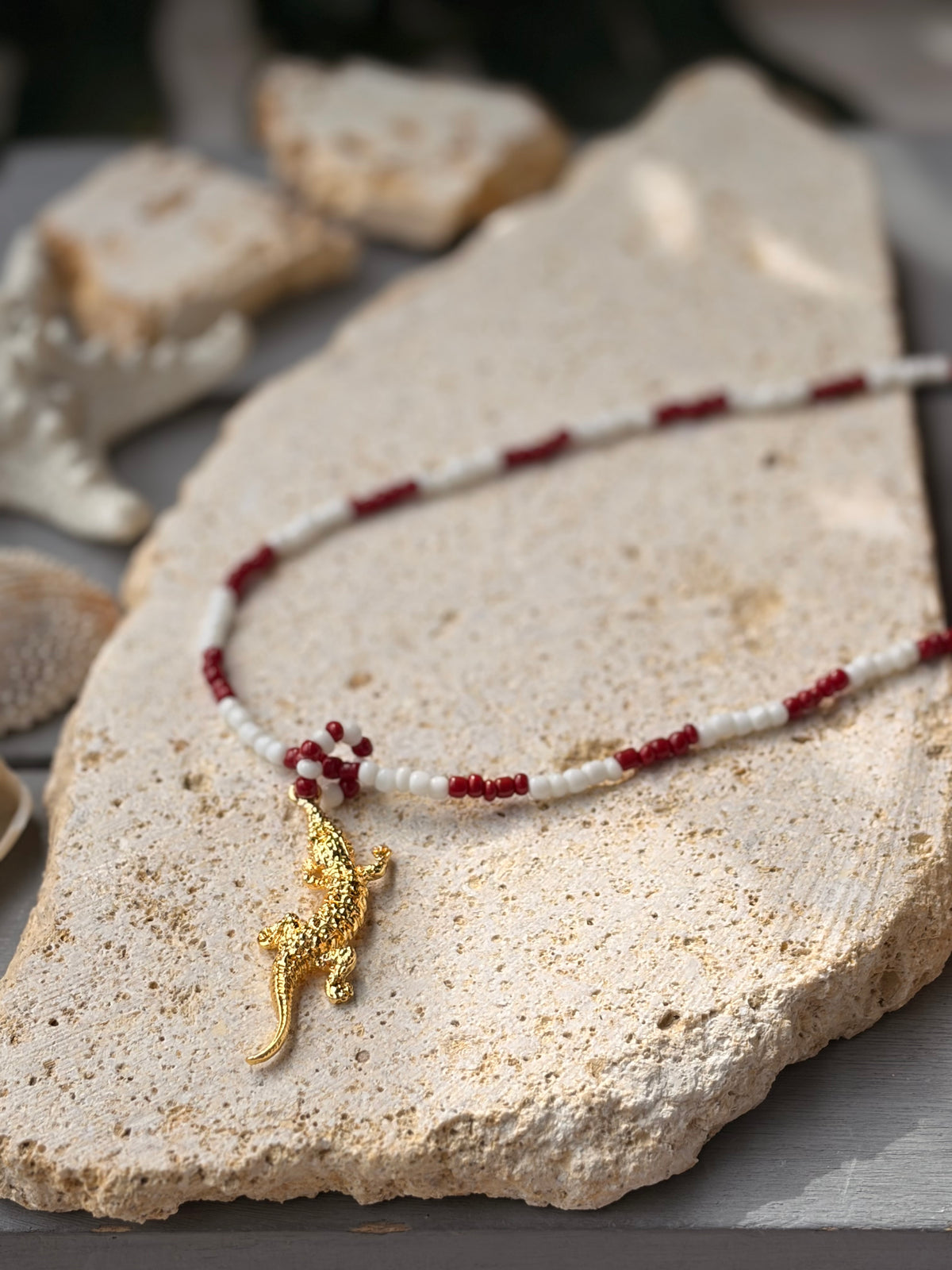 Collar largo tonos vino y blanco dije cocodrilo 24k