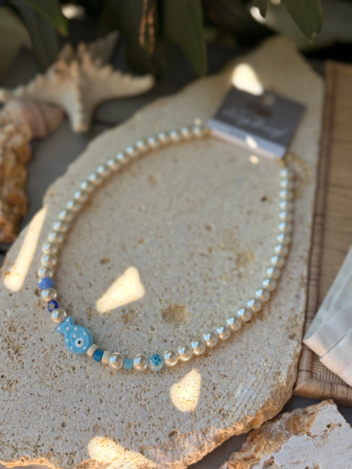 Collar en perlas y dijes azules y pez