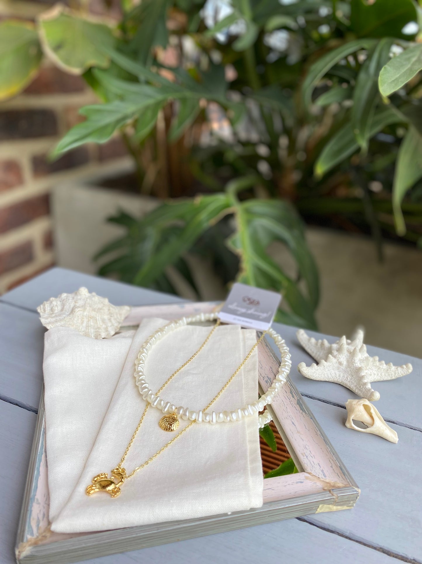 Collar doble perlas y dijes cangrejo y concha