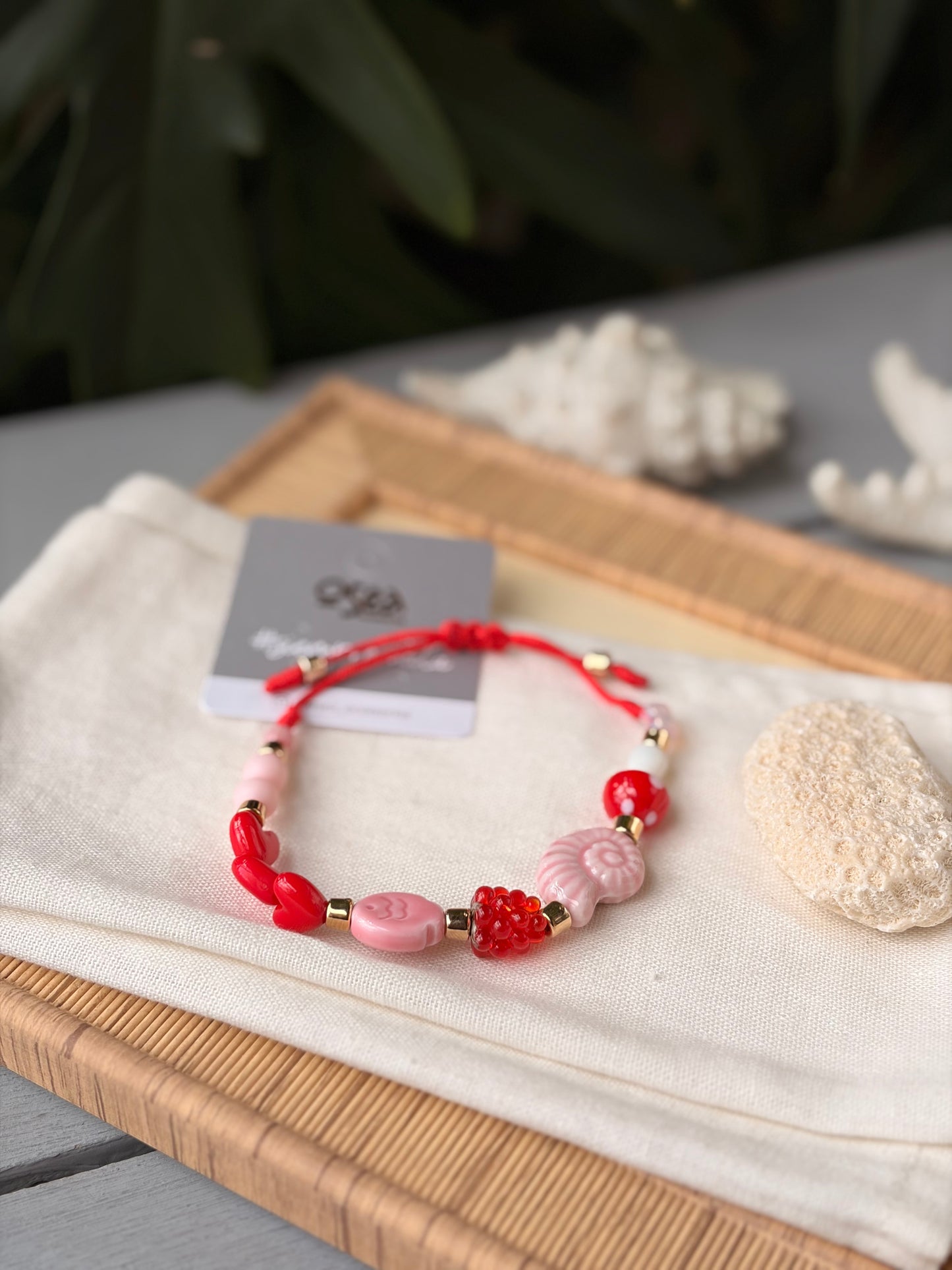 Pulsera hilo dijes rojos y rosados