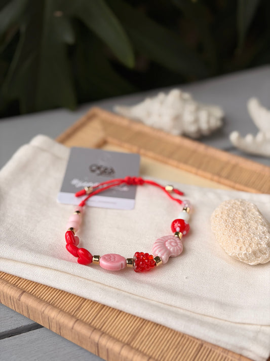 Pulsera hilo dijes rojos y rosados