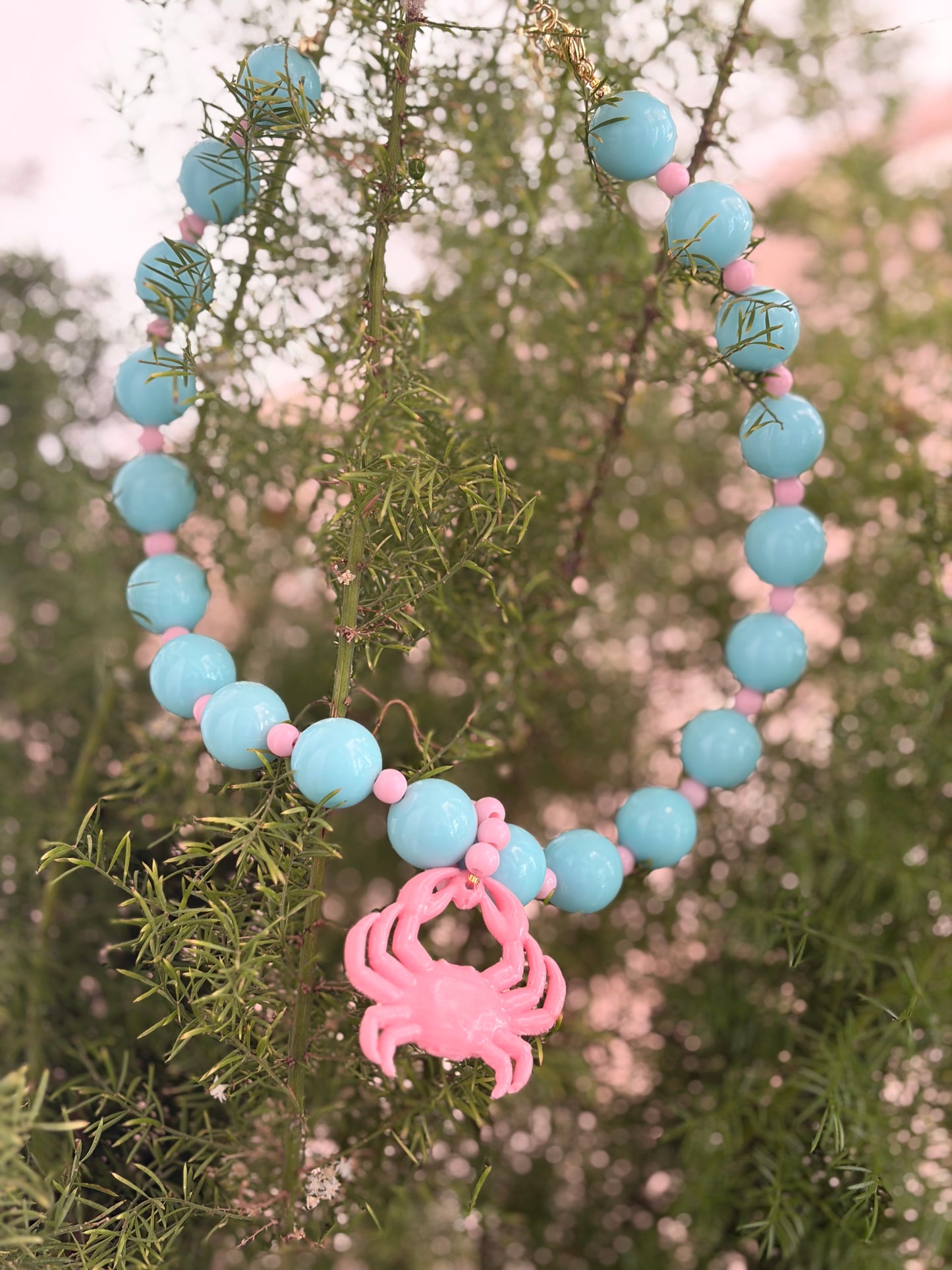 Collar bolas azul cielo dije cangrejo rosado