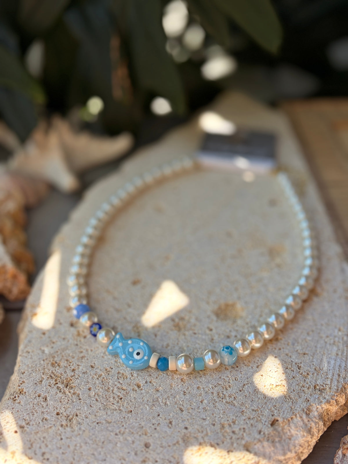 Collar en perlas y dijes azules y pez