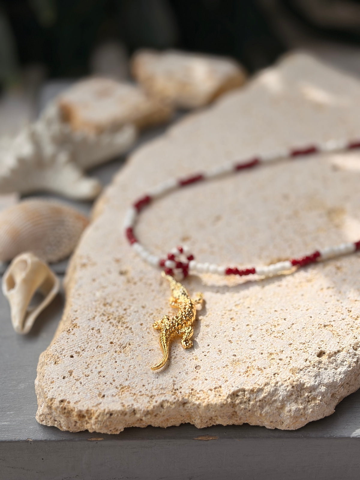 Collar largo tonos vino y blanco dije cocodrilo 24k