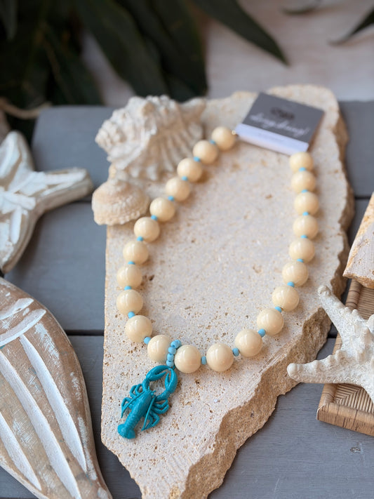 Collar bolas beige dije langosta azul