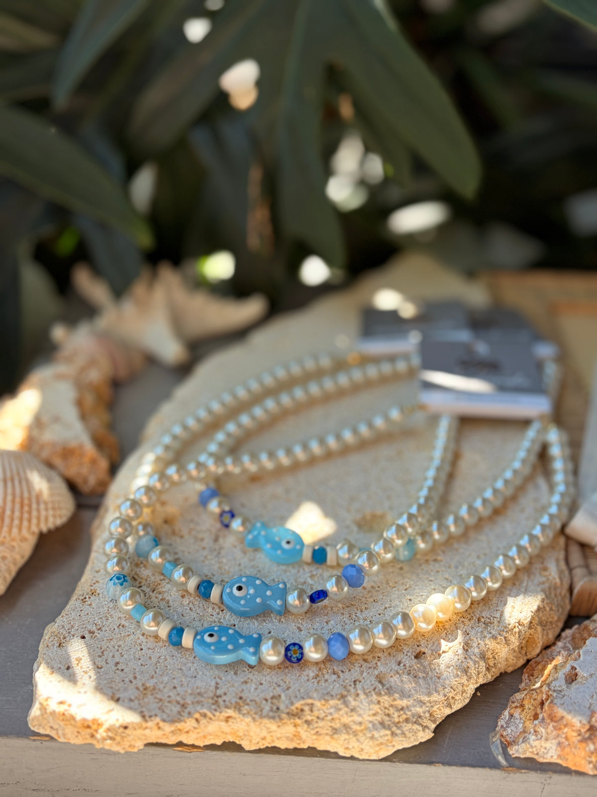 Collar en perlas y dijes azules y pez