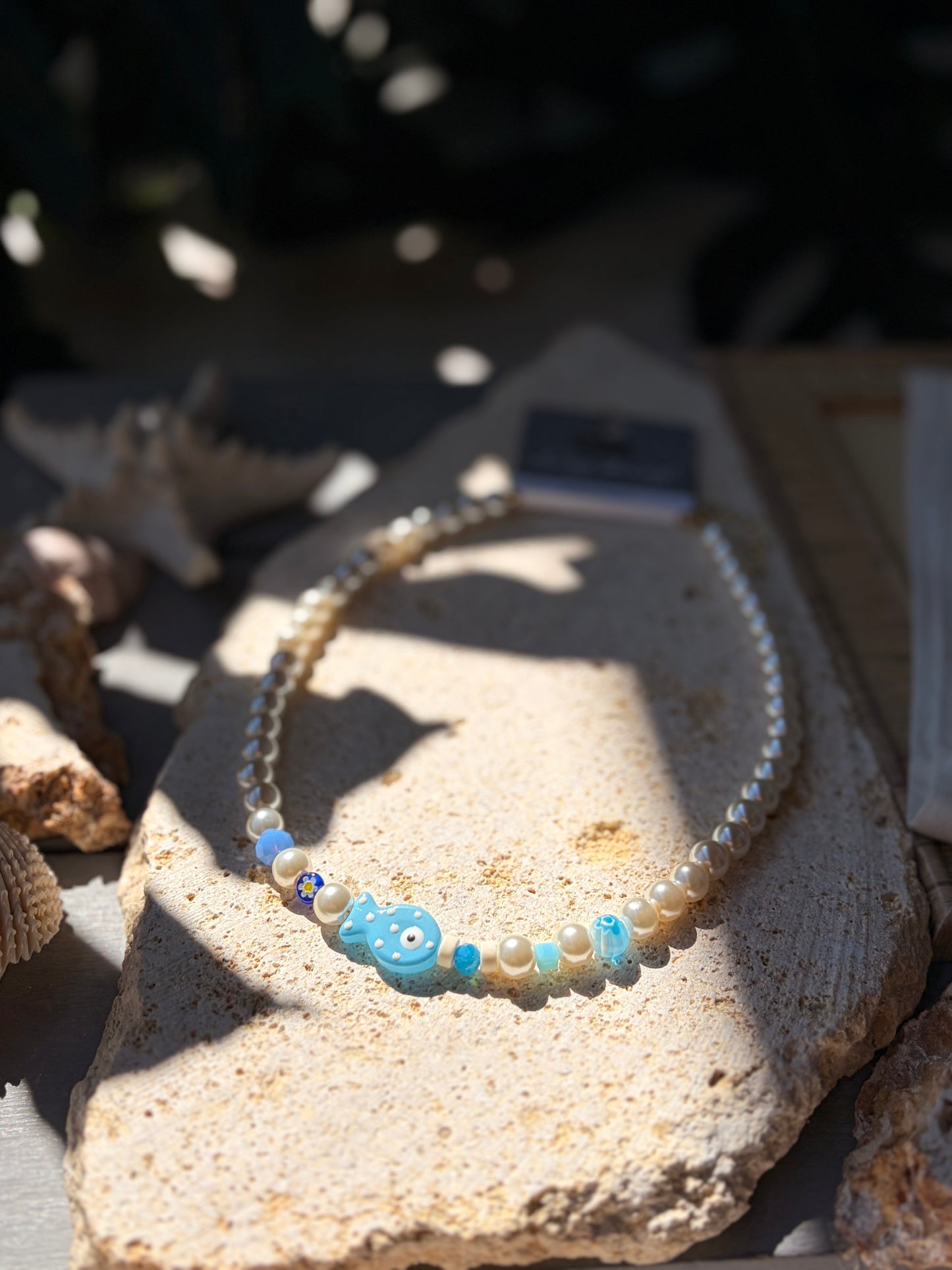 Collar en perlas y dijes azules y pez