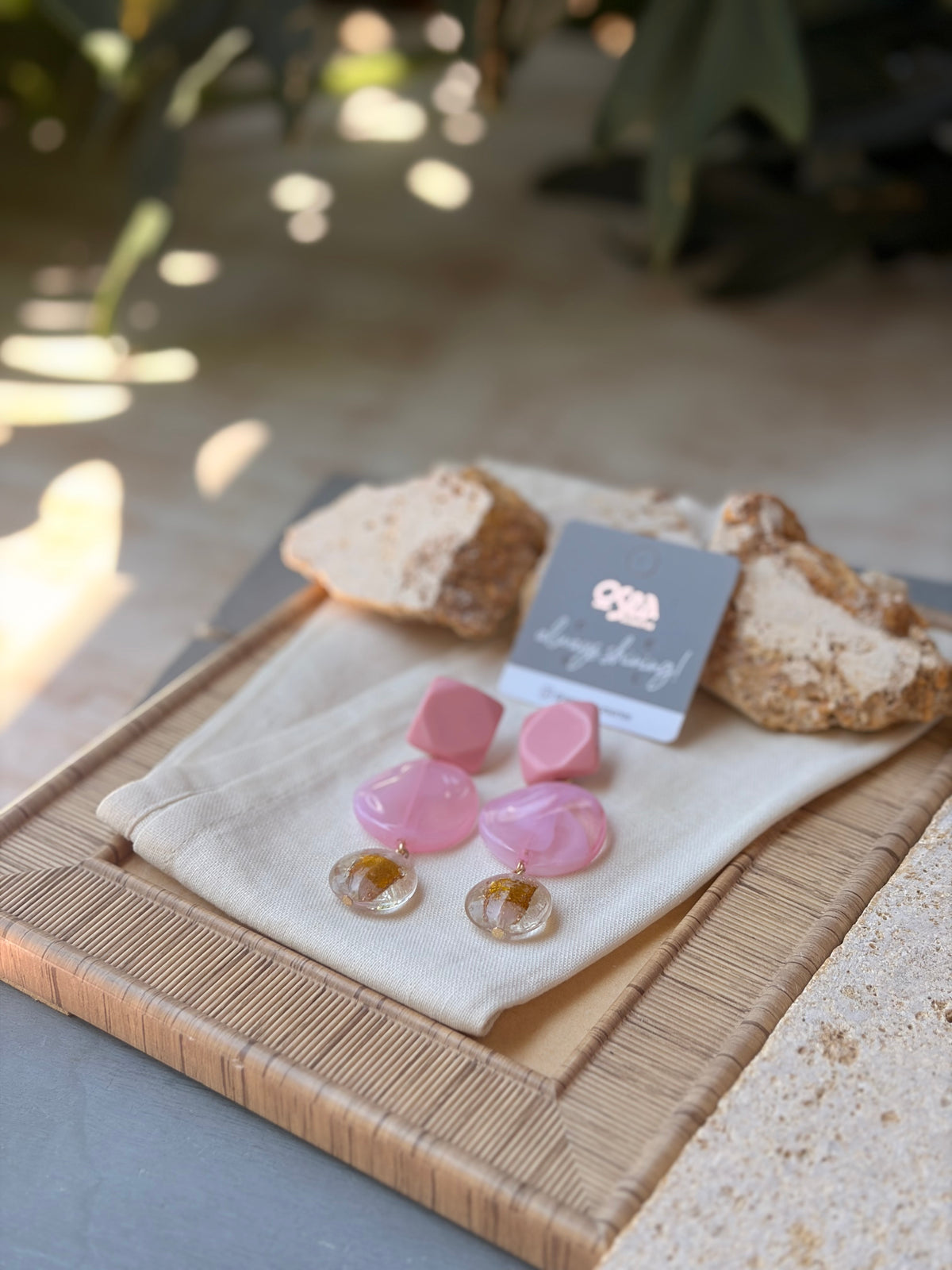 Aretes en resina rosados con dije transparente