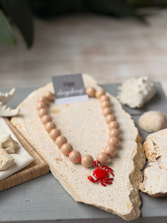 Collar bolas beige dije cangrejo rojo